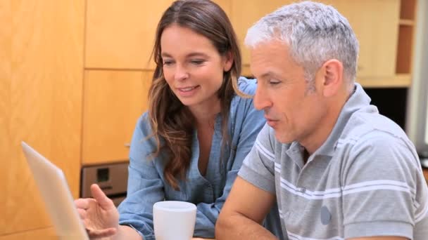 Smiling couple talking in front of a laptop — Stock Video