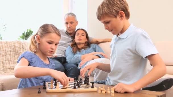 Frères et sœurs souriants jouant aux échecs — Video