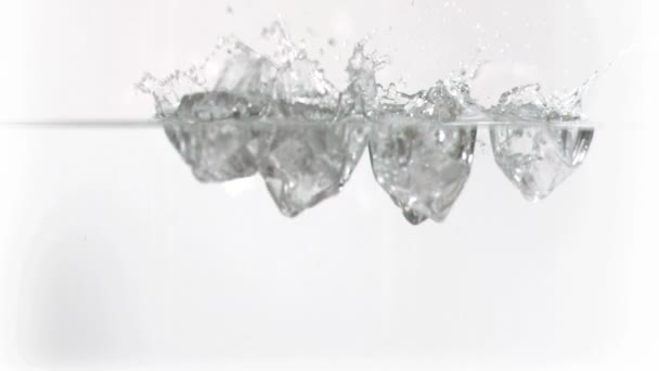 Ледяные кубики, падающие в воду в супер медленном движении — стоковое видео