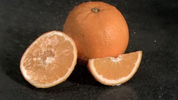Вода падает на апельсины в замедленной съемке — стоковое видео