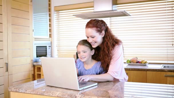 Smiling mother using a laptop with her daughter — Stock Video