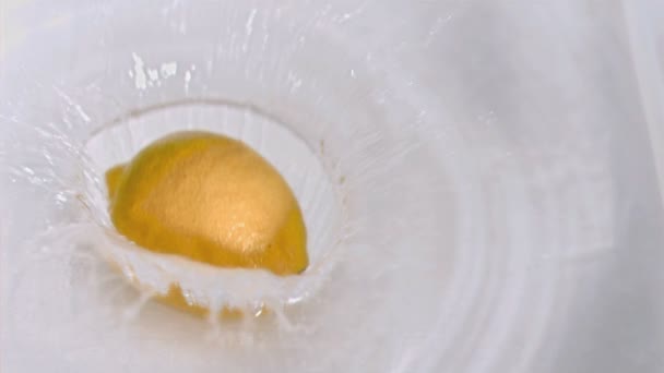 Лимон падает в воду в замедленной съемке — стоковое видео