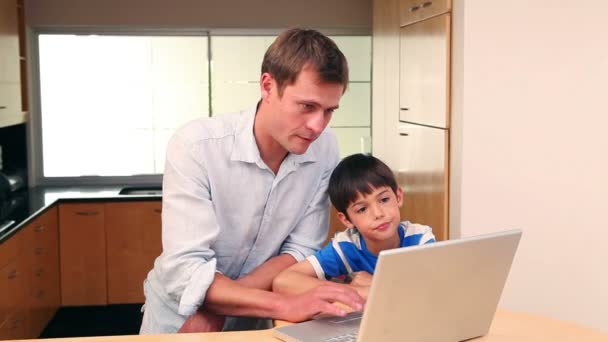 Padre e hijo con portátil en la cocina — Vídeo de stock