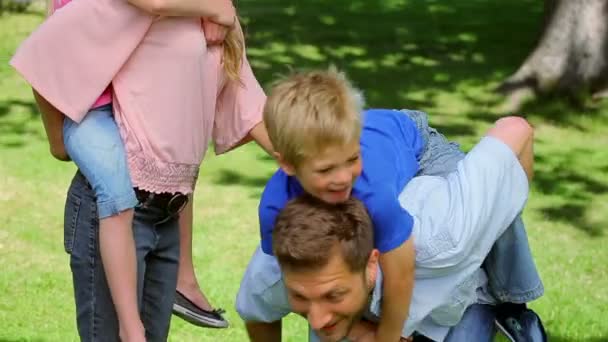 Jongen loopt en springt op zijn vaders terug die geeft hem een piggy-back — Stockvideo