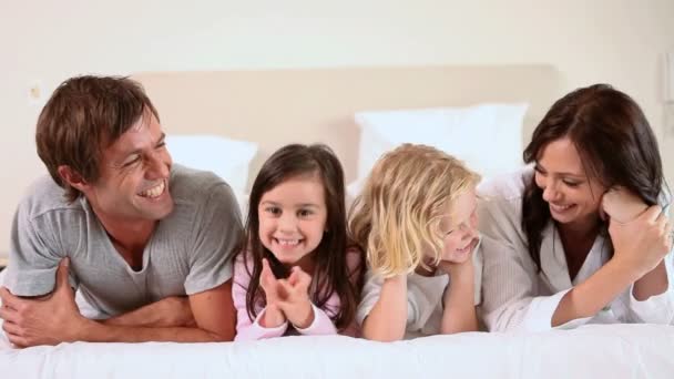 Família deitada juntas em uma cama — Vídeo de Stock