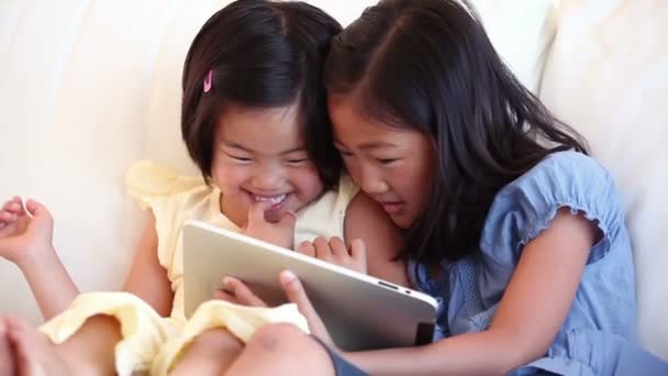 Two sisters using a tablet computer together — Stock Video