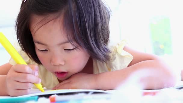 Girl colouring in a colouring book — Stock Video