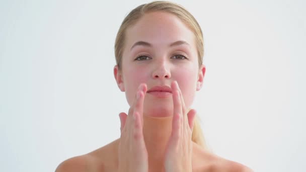 Mujer rubia sonriente frotando sus dos mejillas — Vídeos de Stock