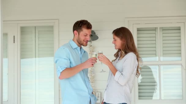 Man och en kvinna som spottar glas champagne innan håller varandra — Stockvideo