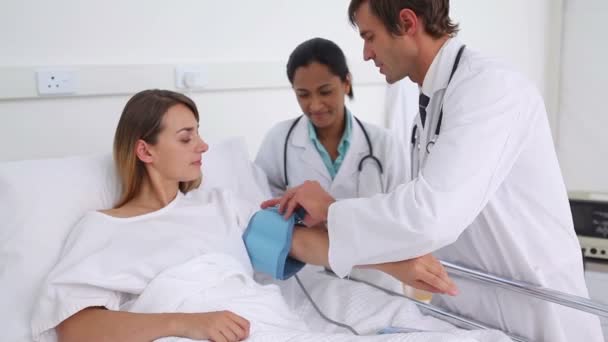 Доктор измеряет давление у пациента — стоковое видео