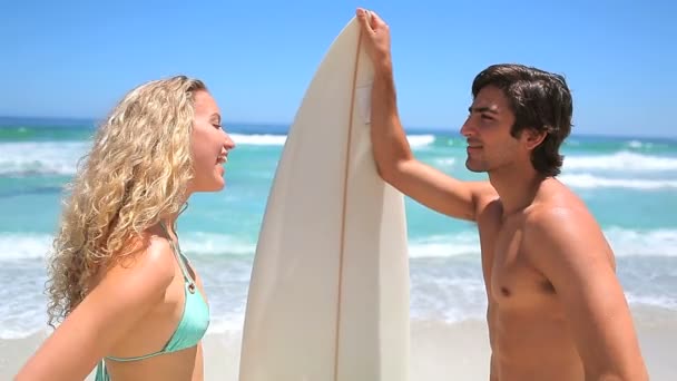 Blondine flirtet mit einem Surfer — Stockvideo