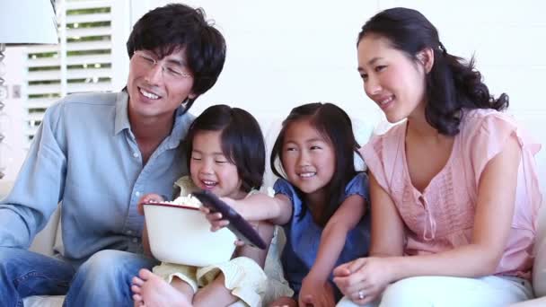 Familia viendo televisión con un tazón de palomitas de maíz — Vídeos de Stock