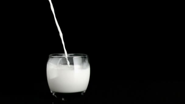 Goteo de leche en cámara súper lenta cayendo en un vaso — Vídeos de Stock