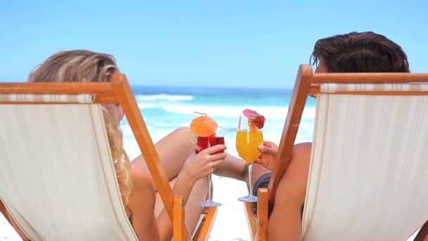 Couple on deck chairs drinking cocktails — Stock Video