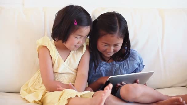 Zwei Mädchen, die gemeinsam einen Tablet-Computer benutzen — Stockvideo