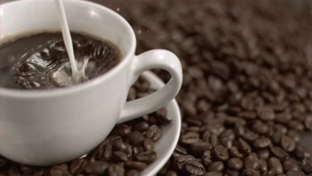 Leche fluyendo en cámara súper lenta en taza de café — Vídeos de Stock