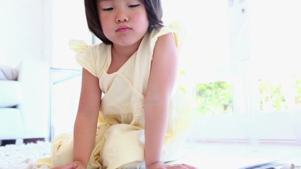 Κορίτσι χρωματισμός σε ένα βιβλίο στο πάτωμα — Αρχείο Βίντεο