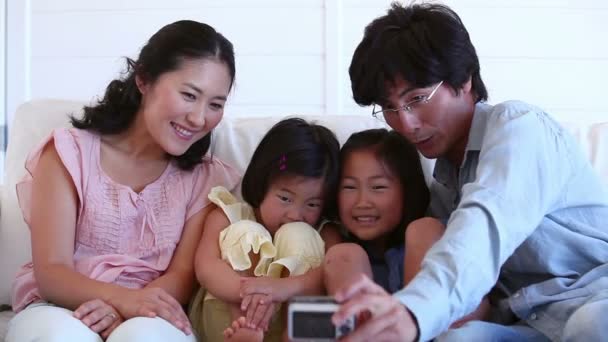 Familia sacándose una foto mientras se sientan juntos — Vídeos de Stock