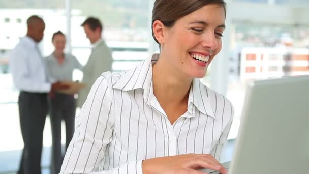 Бізнес-леді посміхається, коли вона використовує ноутбук — стокове відео