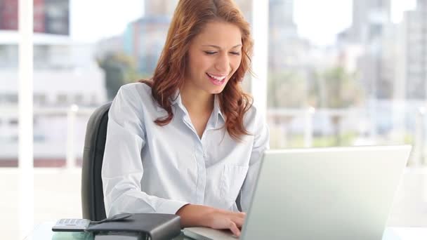 Secretaria sonriente usando un portátil — Vídeos de Stock