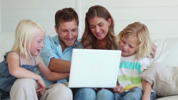 Familia sentada junta mientras usa un portátil — Vídeo de stock