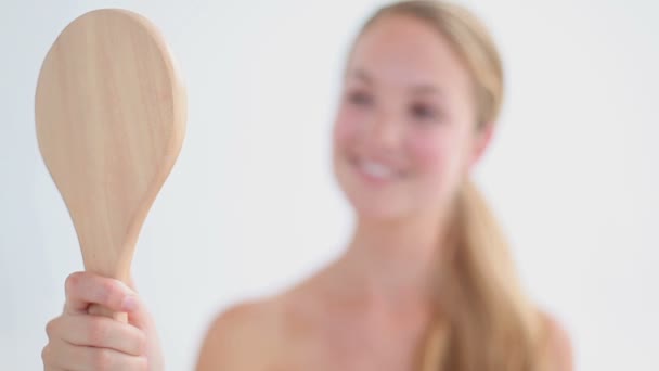 Smiling blonde woman holding a mirror — Stock Video