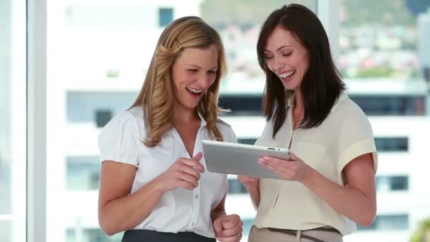 Дві жінки-працівниці використовують електронну книгу — стокове відео