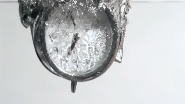 Alarm clock in super slow motion falling in the water — Stock Video