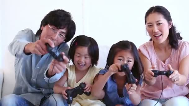 Семья счастливо играет на игровой консоли вместе — стоковое видео