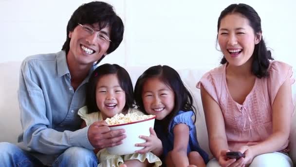 Семья смотрит телевизор и ест попкорн — стоковое видео