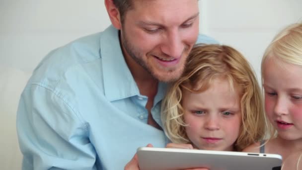 Familia viendo algo en una tableta juntos — Vídeo de stock