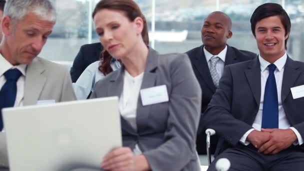 Mensen die een laptop gebruikt terwijl een zakenman naar de camera kijkt — Stockvideo