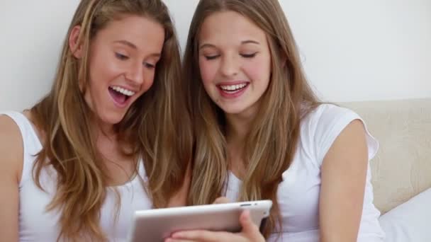 Heureux amis brunes regardant une tablette informatique — Video