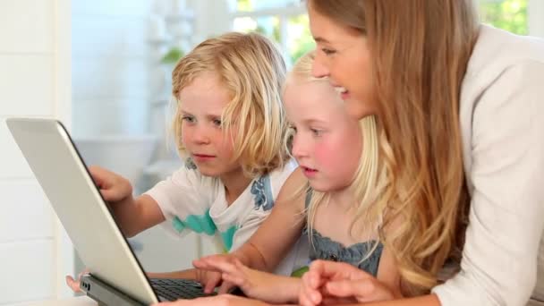 Moeder met behulp van een laptop met haar kinderen — Stockvideo