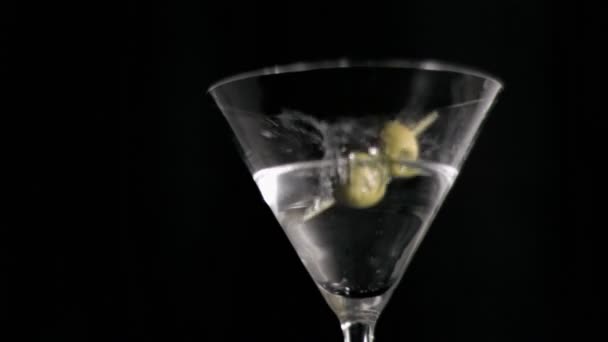 Olive skewer falling in super slow motion in a glass — Stock Video