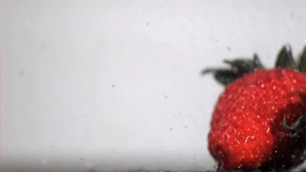 Wasser fällt in Superzeitlupe auf rote Früchte — Stockvideo