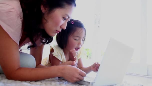 Mère et fille couchées ensemble tout en utilisant un ordinateur portable — Video