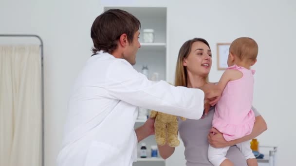 Arzt schenkt einem Baby einen Teddybär — Stockvideo