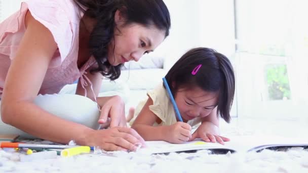 Madre mirando a su hija mientras colorea — Vídeo de stock