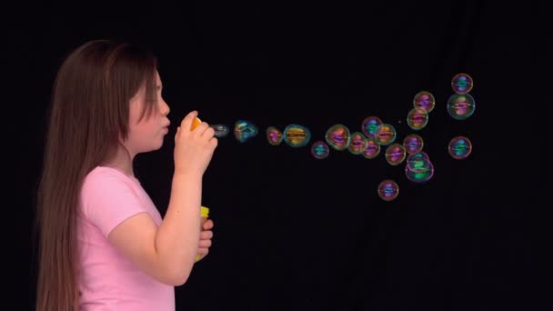 Side view of a little girl making bubbles — Stock Video