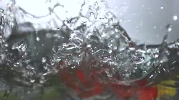 Vele chilipepertjes vallen in water — Stockvideo