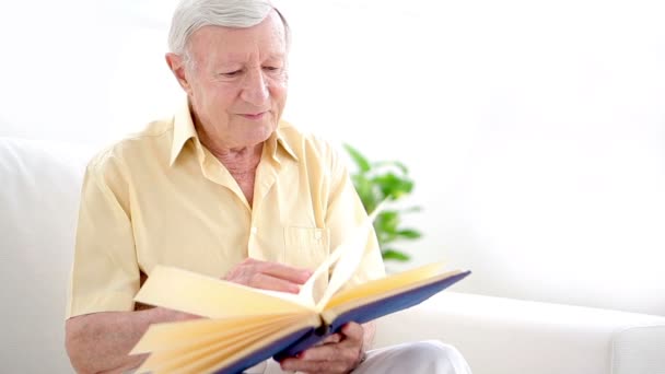 Viejo mirando a través de álbum de fotos — Vídeo de stock