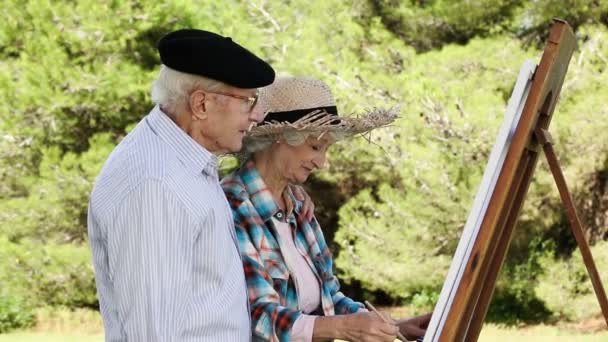 Old couple painting in the park — Stock Video