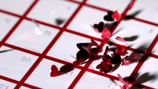 Corazón rojo oscuro confeti cayendo en el calendario — Vídeos de Stock