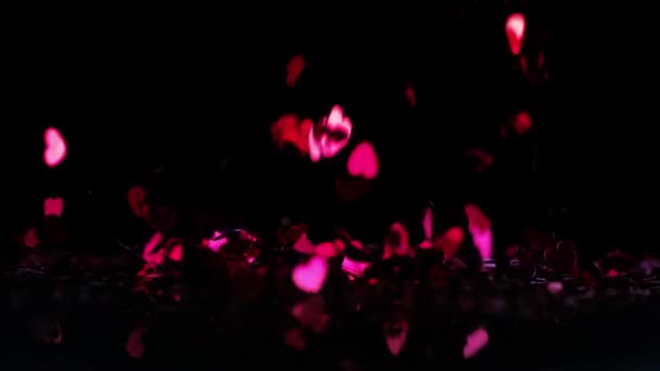 Siyah arka plan üzerine yağan pembe kalp konfeti — Stok video