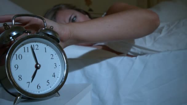 Waking up woman pushing down the alarm clock — Stock Video