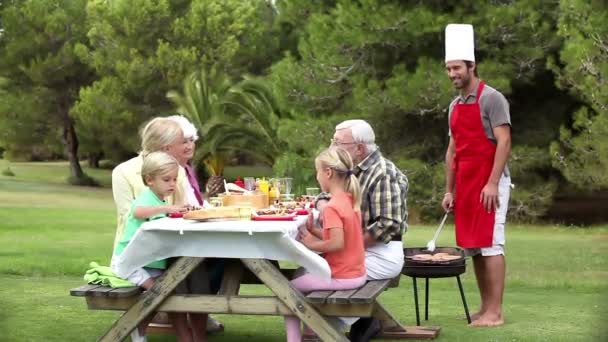 Padre cocina barbacoa para la familia — Vídeo de stock