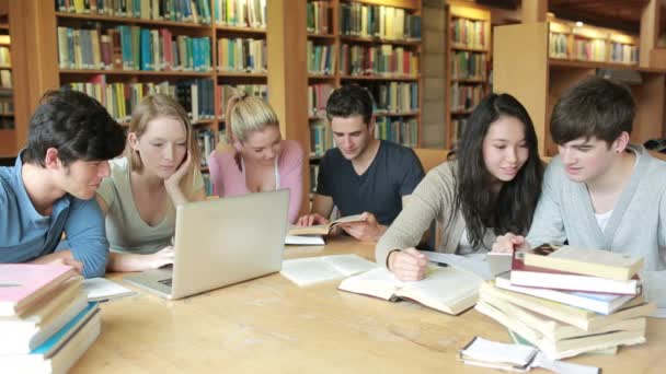 Estudiantes aprendiendo en una biblioteca — Vídeos de Stock