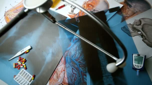 Stetoskop falla över x ray bredvid andra medicinska verktyg — Stockvideo