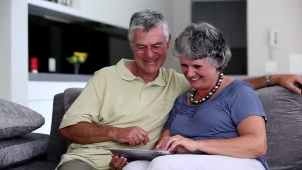 Зрелая пара использует планшетный компьютер вместе — стоковое видео